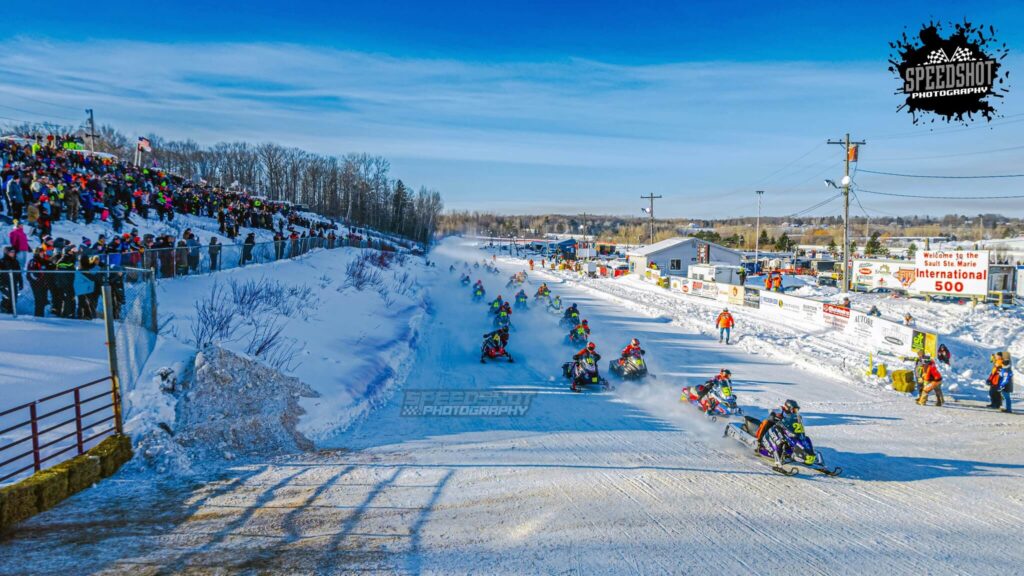 International 500 snowmobile endurance racers competing on the oval ice track